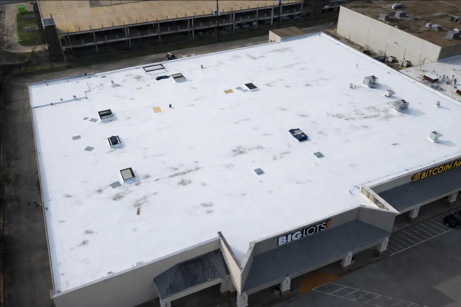 Aerial view of a large TPO membrane roof on a big-box retail building with rooftop equipment