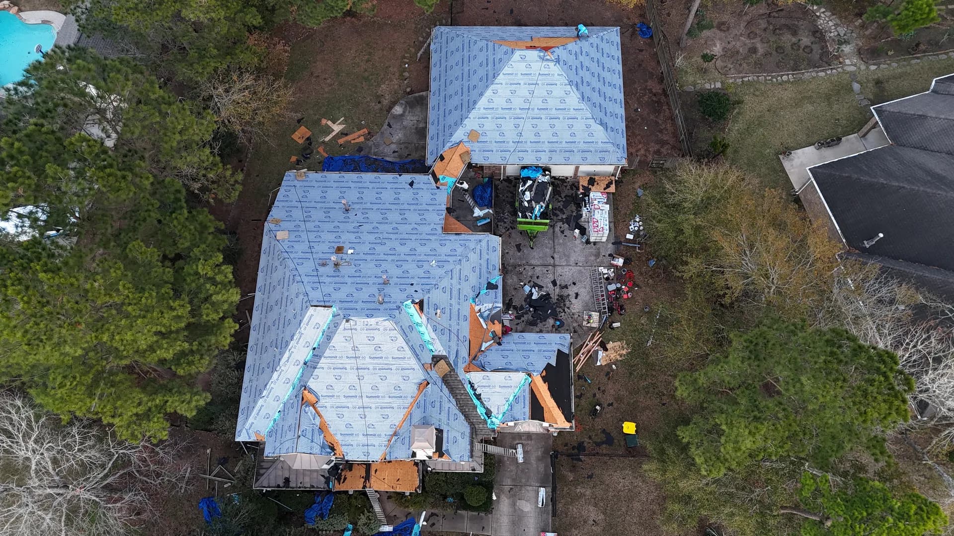 Roof stripped to underlayment mid-job, the exposed condition a temporary tarp is meant to protect until permanent repair