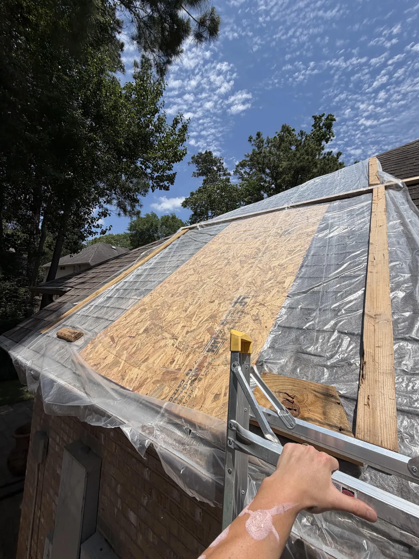 Close view of roof sheathing panels and seams exposed during a tear-off, where decking condition is assessed