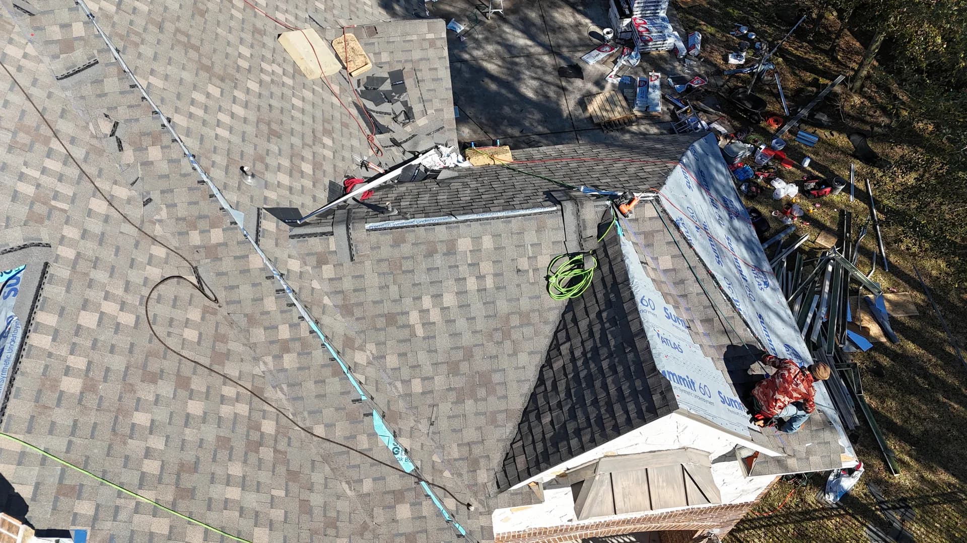 Roof deck covered in underlayment under full sun, the surface that drives attic temperature in Texas heat