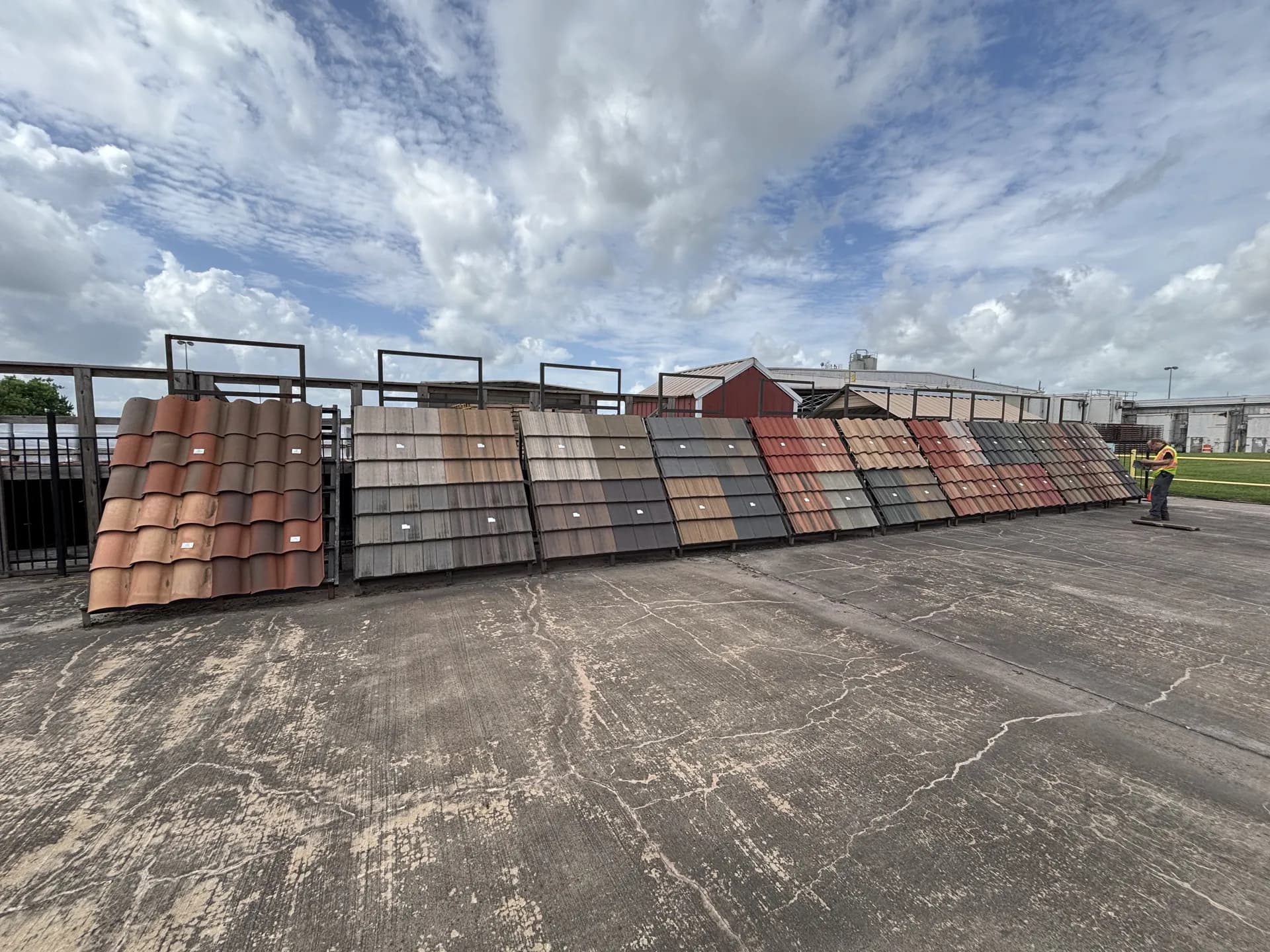 Rows of concrete tile roofing material samples in multiple colors at a supplier yard used by ROYH Build Co near The Woodlands, TX