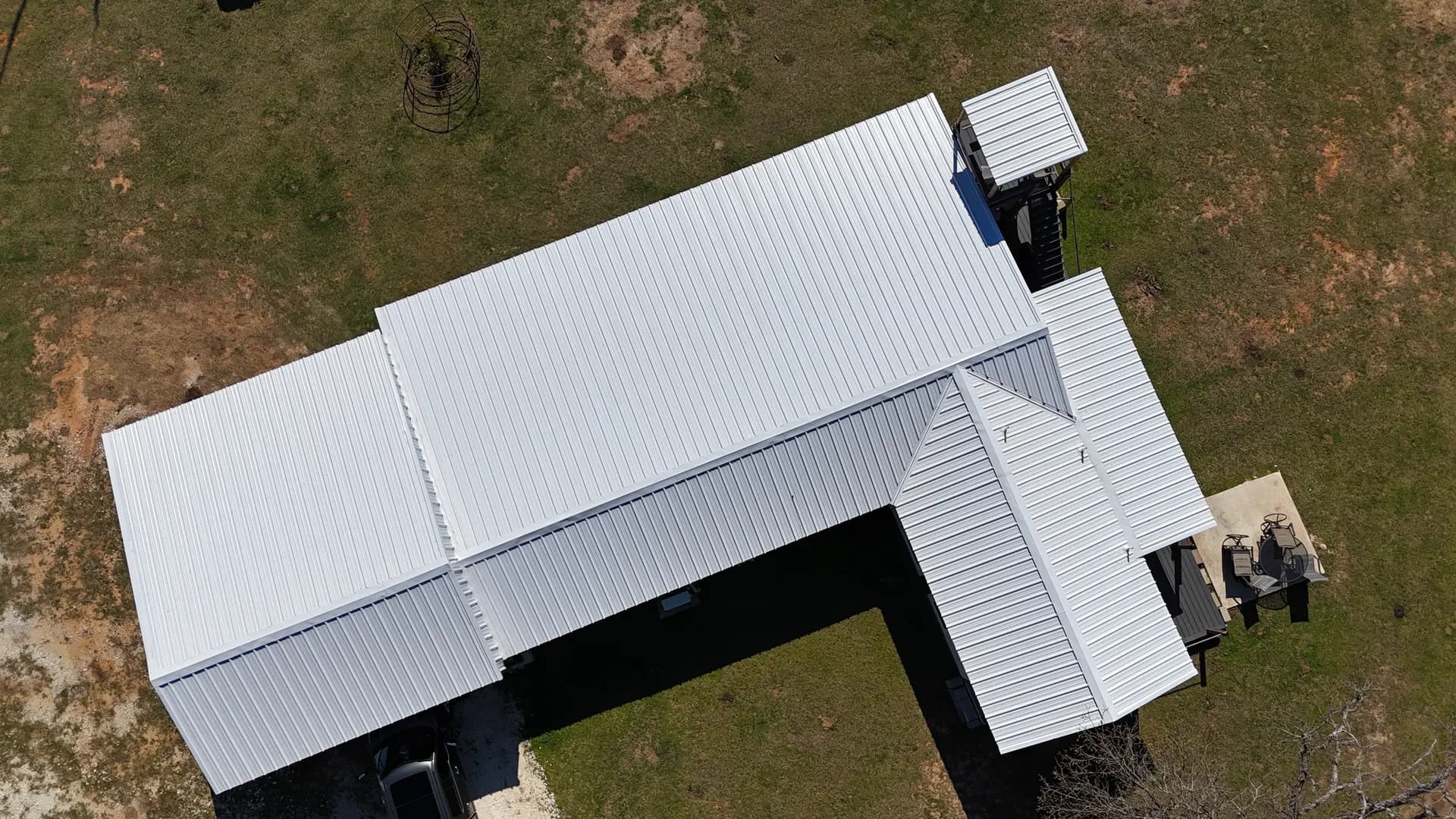Aerial view of a white standing seam metal roof installed by ROYH Build Co near The Woodlands, TX