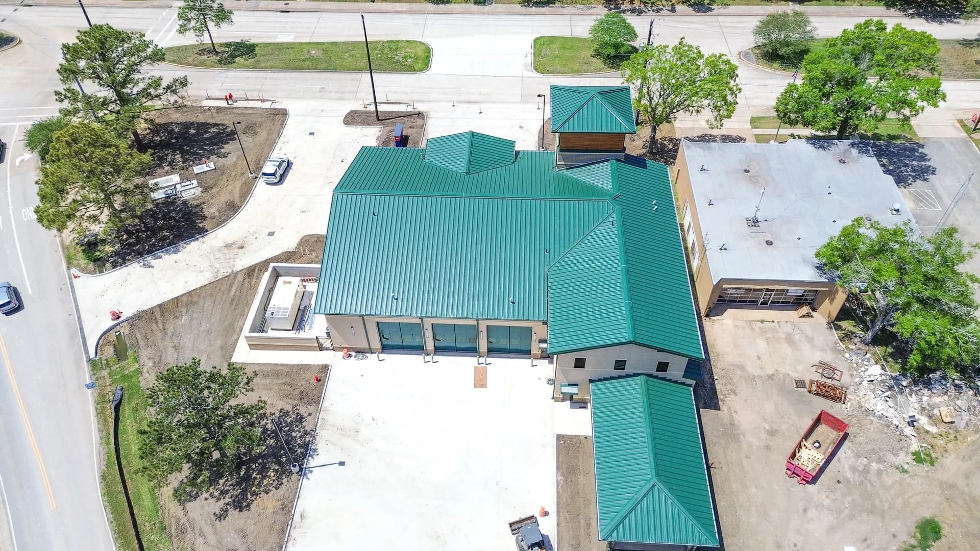 New exposed fastener R-panel metal roof on a home under construction, the panel type that anchors the lower end of metal roofing cost