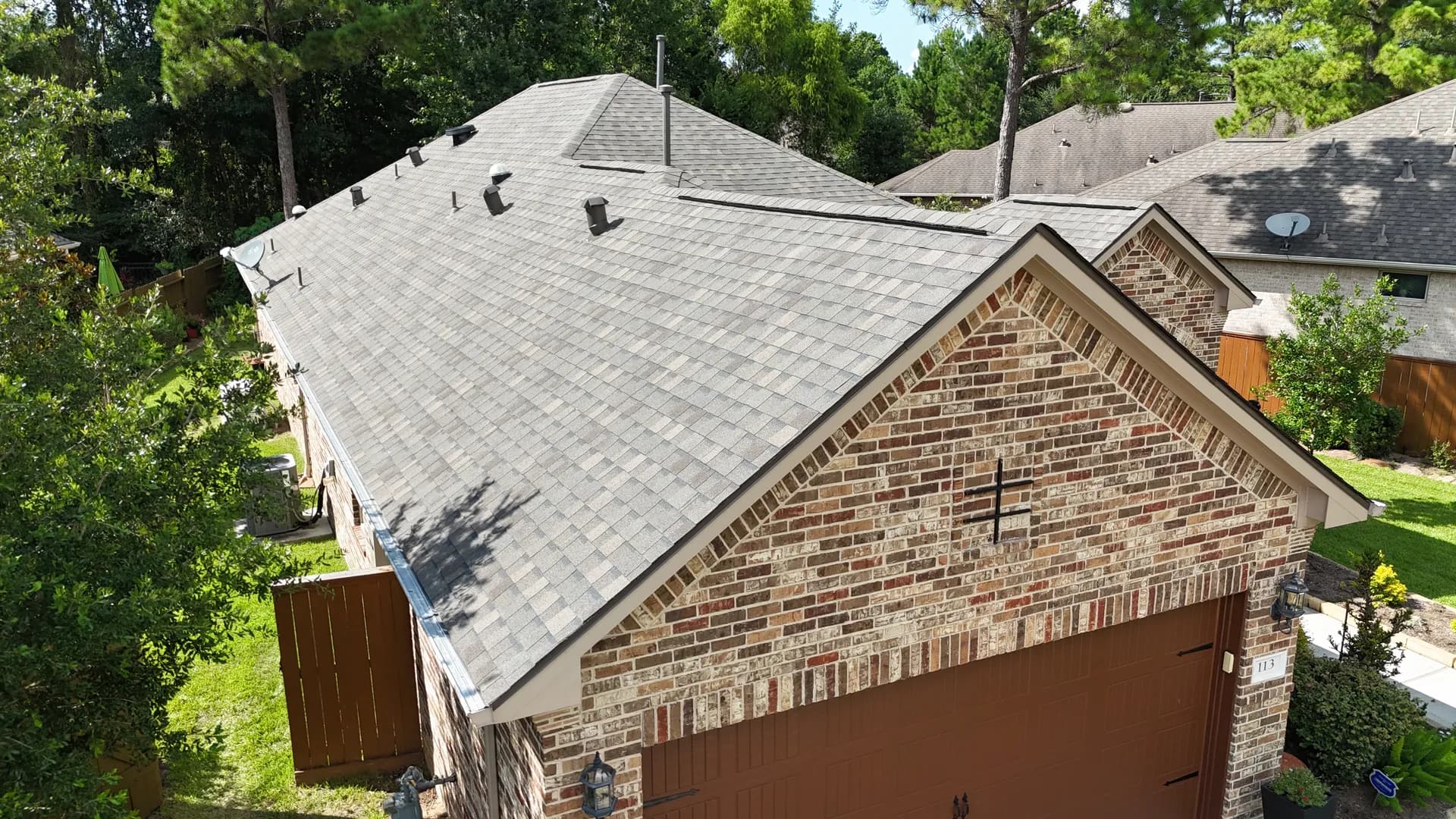 Aerial view of a finished gray architectural asphalt shingle roof on a home near The Woodlands, TX