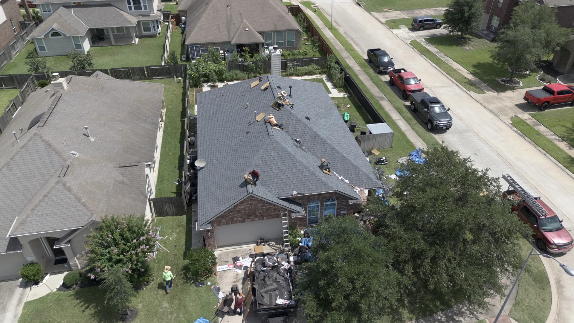 Aerial drone view of a completed gray architectural shingle roof on a home with a hip roof and dormer