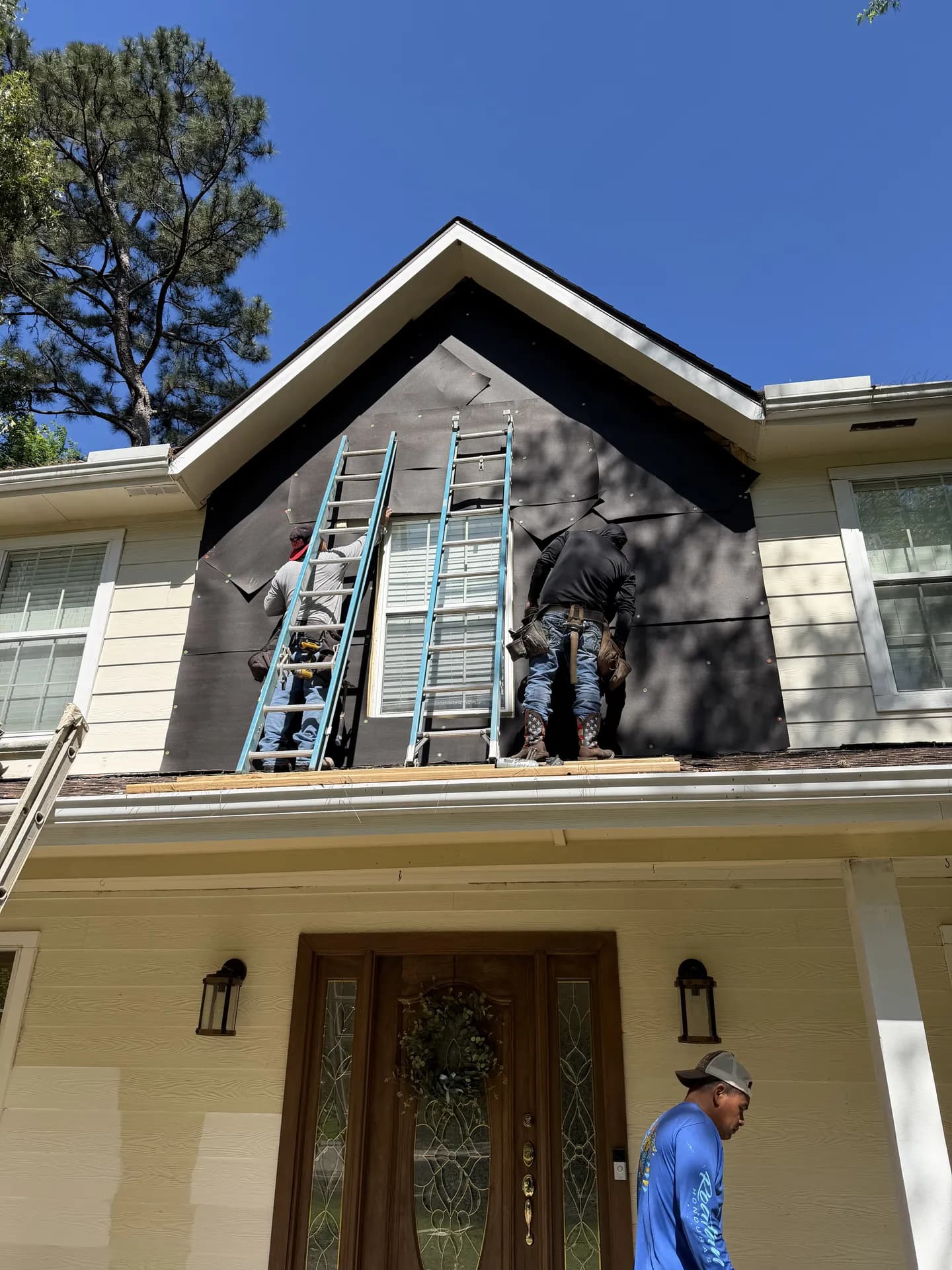 ROYH Build Co crew installing new board and batten style siding panels on a home's gable end during a siding project